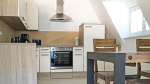 Eine moderne Küche mit Einbauofen, einer Kaffeemaschine und einem Kühlschrank.