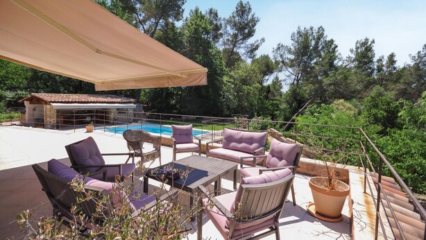 An outdoor patio with seating and a pool.