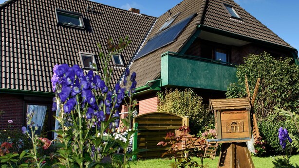 A house with a sloped roof, solar panels, and a green balcony. - 101 (BC 5) - BUE - Apartment house Hansen (Büsum)