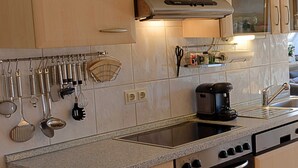 A kitchen with granite countertops, stainless steel appliances, and wooden cabinets. - 101 (BC 5) - BUE - Apartment house Hansen (Büsum)