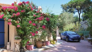 A narrow street with a parked car, potted plants, and a building with a stone facade. - Nice home in Sainte Maxime with WiFi (Sainte Maxime)