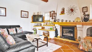 A living room with a fireplace, a television, and a sofa. - Nice home in Sainte Maxime with WiFi (Sainte Maxime)