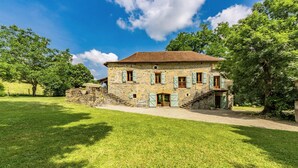 A stone house with a tiled roof, a front porch, and a staircase leading to a second floor. - Gorgeous home in Caylus (Caylus)