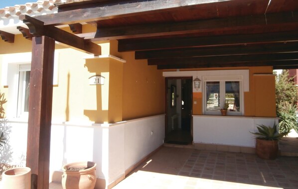 A covered outdoor area with a wooden pergola, a door with a number sign, and potted plants. - Pet friendly home in Torre Pacheco (Torre Pacheco)