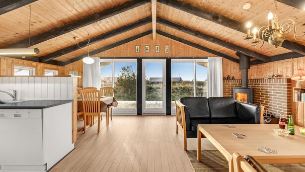 Un accogliente chalet con cucina, zona pranzo e camino.