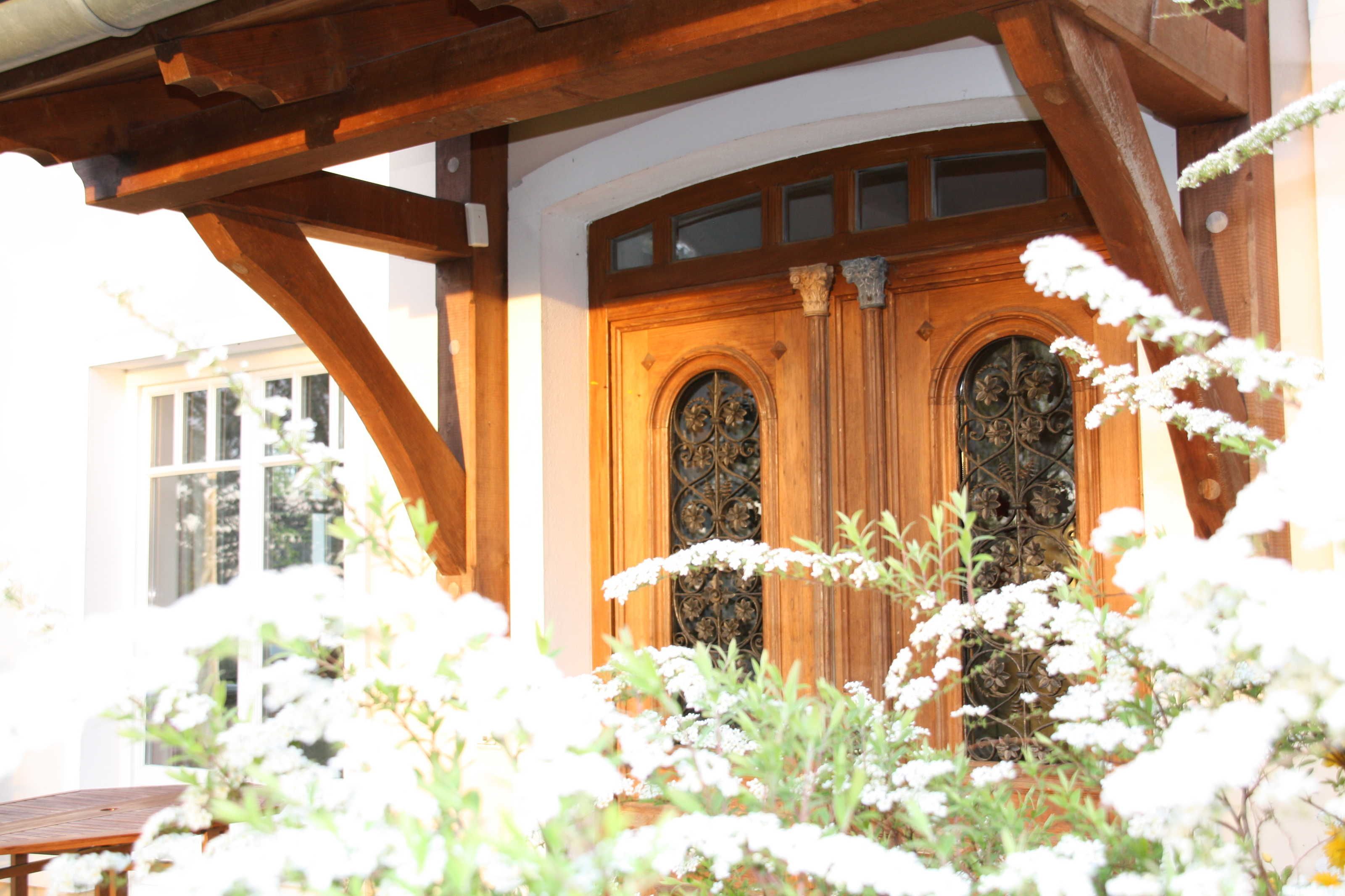 Un bâtiment en bois doté d’une grande porte d’entrée en arc de cercle et d’une fenêtre située au-dessus.