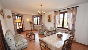 A cozy dining area with a wooden table, chairs, a fan, and a vase of flowers. - Domaine de la Bastide d'Agay (Agay)