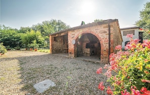 A stone building with an arched entrance and a small patio area. - Awesome apartment in Pietraviva AR (Pietraviva AR)