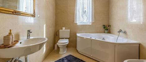 A bathroom with a freestanding bathtub, a sink, and a toilet.