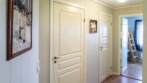 A hallway with three white doors, a wooden ladder, and a framed picture on the wall. - Lovely home in Sveio with WiFi (Sveio)