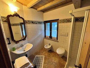 A bathroom with a sink, bidet, toilet, and a shower. - Montain hut with 20,000 square meters of land (Lenzumo)