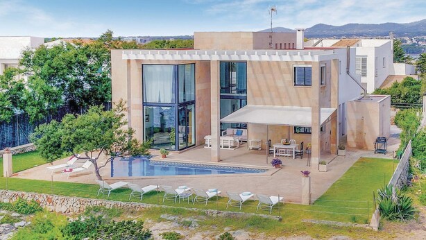 A modern two-story house with a swimming pool, outdoor seating, and a view of the surrounding area.