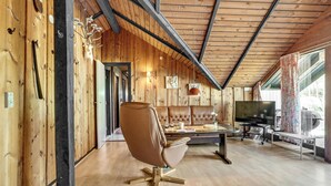 A spacious living area with a leather sofa, a television, and a wooden ceiling. - 3 bedroom awesome home in Hadsund (Hadsund)