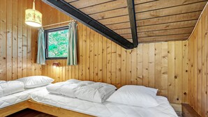 A wooden cabin room with two beds, a window with curtains, and a hanging lamp. - 3 bedroom awesome home in Hadsund (Hadsund)
