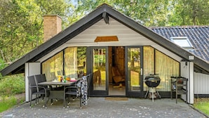 A cozy cabin with a dining area, a grill, and a large sliding glass door. - 3 bedroom awesome home in Hadsund (Hadsund)