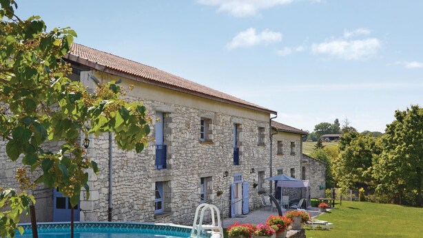 Un bâtiment en pierre doté d’une piscine, d’un espace extérieur aménagé et d’un jardin.