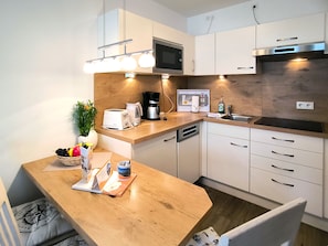 A modern kitchen with a microwave, toaster, coffee maker, and sink. - Haus Meeresblick FeWo Albatros A 2.33 Ref. 243476 - FeWo Albatros A 2.33 Ref. (Baabe)