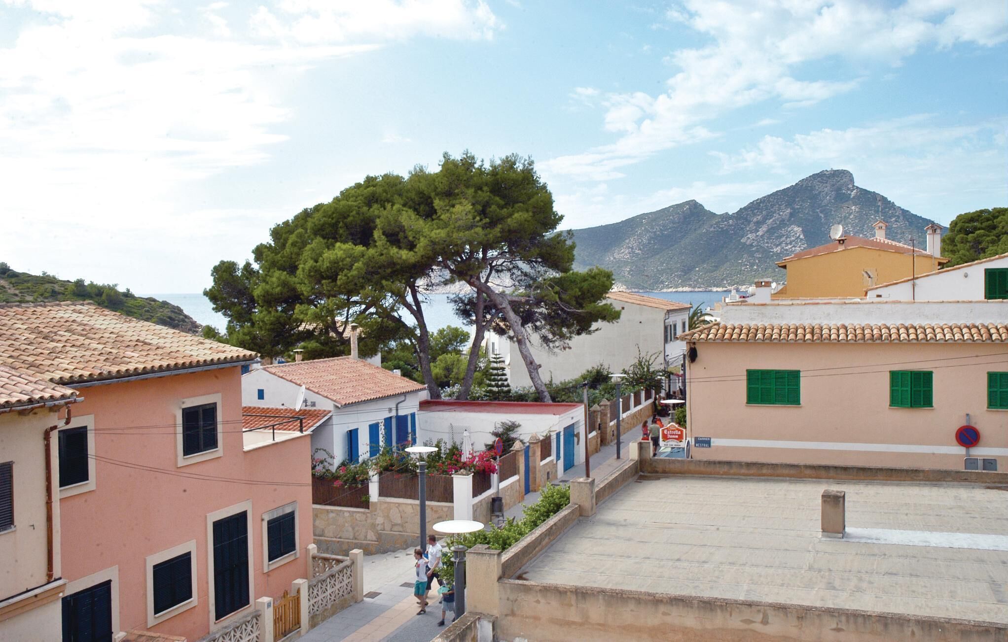 A coastal town with traditional Mediterranean architecture, including terracotta-tiled roofs and pastel-colored buildings.