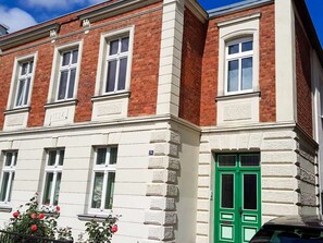 En toetages bygning med rød murstensfacade og hvidt dekoration.