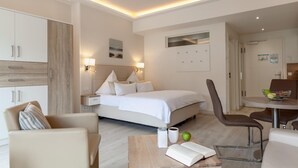 Ein Hotelzimmer mit Bett, Nachttisch, Stuhl und einer kleinen Essecke.