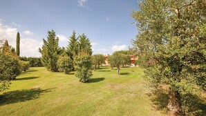 A well-maintained garden with various trees and a lawn. - Stunning home in Orentano PI (Orentano PI)