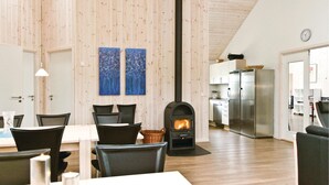 A modern kitchen with a built-in stove, stainless steel appliances, and a dining area with a table and chairs. - Beautiful home in Vejers Strand with sauna (Vejers Strand)
