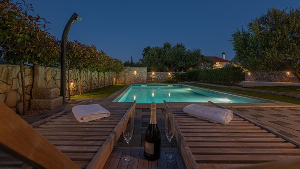 A swimming pool with a wooden deck, two towels, and two glasses of wine. - Amazing home in Zaton (Zaton)