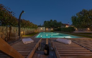 A swimming pool with a wooden deck, two towels, and two glasses of wine. - Amazing home in Zaton (Zaton)