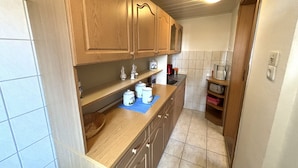Una cocina estrecha con armarios de madera, una encimera y un salpicadero de azulejos.