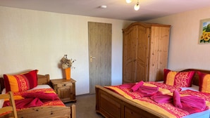 Un dormitorio con cama y mesita de noche de madera, una silla y un armario.