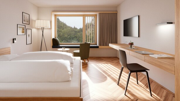 A hotel room with a bed, desk, chair, TV, window, and lamp.
