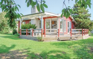 Charming single-story house with a covered porch and beautifully manicured lawn.