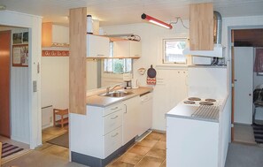 Kitchen area with sink, stove, and central island, featuring a coffee maker and kettle.