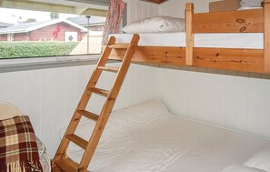 Cozy retreat with a bunk bed and ladder, offering a simple, functional space with a window view of the surrounding greenery.
