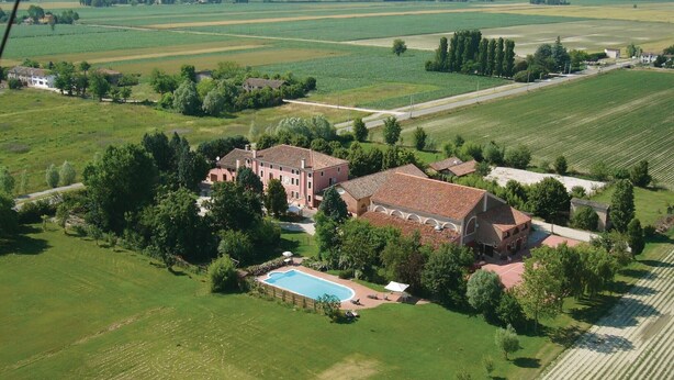 Un vaste domaine comprenant plusieurs bâtiments, une piscine et de vastes espaces verts.