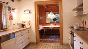 Eine Küche mit Holzausstattung, einer Arbeitsplatte mit Toaster, einem Spülbecken und einem Fenster mit Vorhängen.