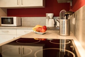 Eine Küche mit Mikrowelle, Kaffeemaschine und einer Obstschale auf der Arbeitsfläche.