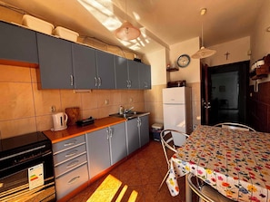 A compact kitchen with grey cabinets, a sink, a stove, and a refrigerator. - Holiday Apartment with Balcony and View (Crikvenica)