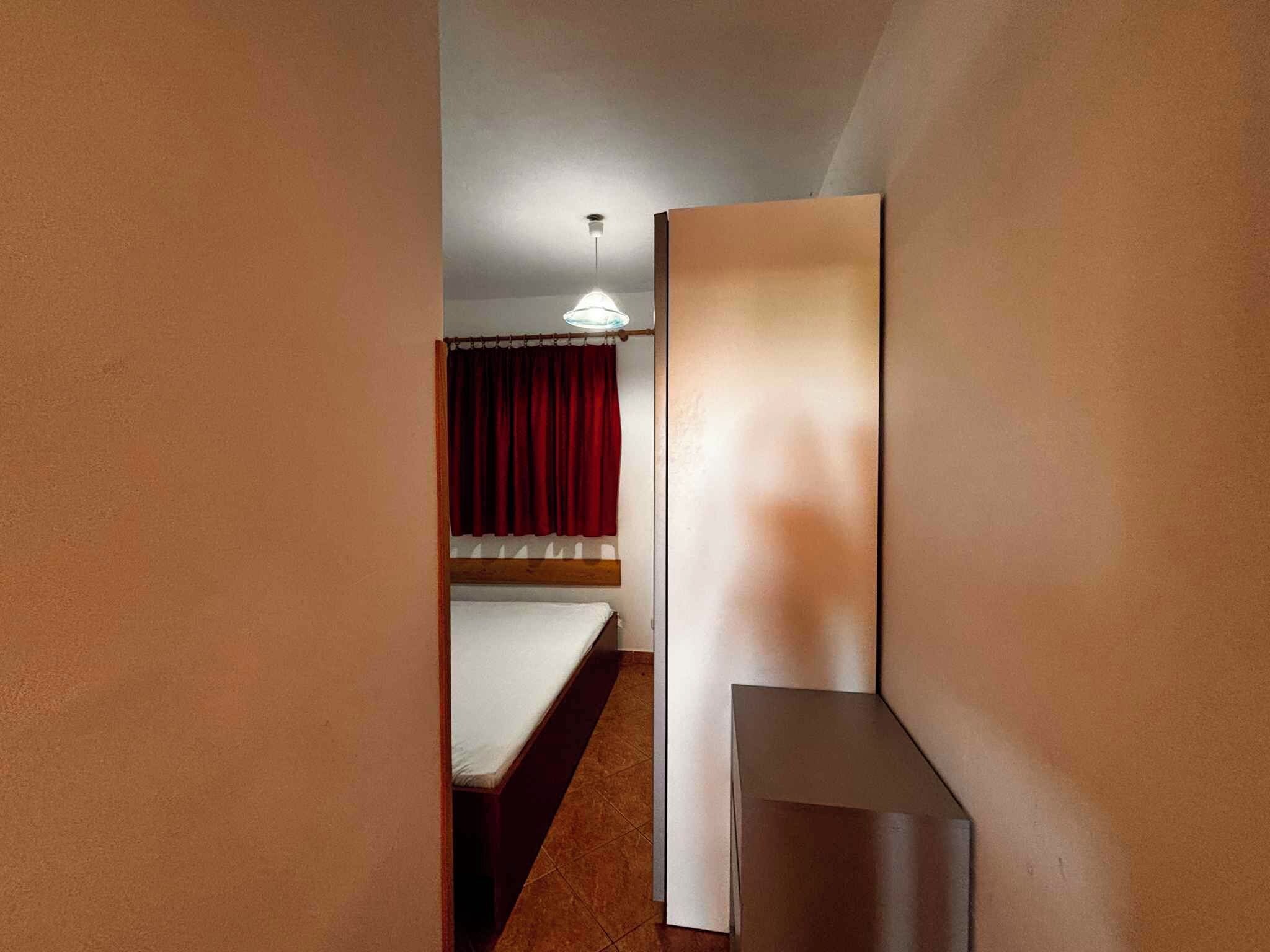A room with a bed, a desk, and a wardrobe.
