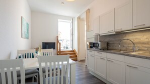 A modern kitchen with white cabinets, a microwave, and a wooden countertop. - 24-08 - resort Villa Apt 24-08. (Kühlungsborn)