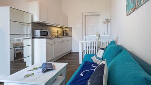 A compact living space with a kitchenette, a dining area, and a sofa. - 24-08 - resort Villa Apt 24-08. (Kühlungsborn)