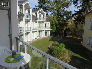 A multi-story hotel with balconies, a courtyard, and surrounding greenery.