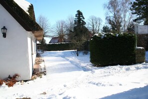 Un sendero cubierto de nieve que lleva a un edificio con un letrero que indica 'Haus 1795'.