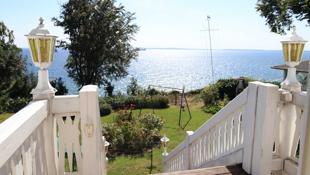 Una escalera de madera blanca con vista al mar.