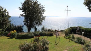 Un jardín con un columpio, un veleta y vistas al mar.
