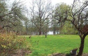 A grassy field with trees and a body of water in the background. - 2 bedroom cozy home in Kosta (Kosta)