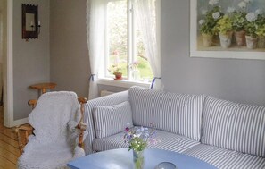 A cozy room with a striped sofa, a small wooden chair, a white towel, and a window with curtains. - 2 bedroom cozy home in Kosta (Kosta)