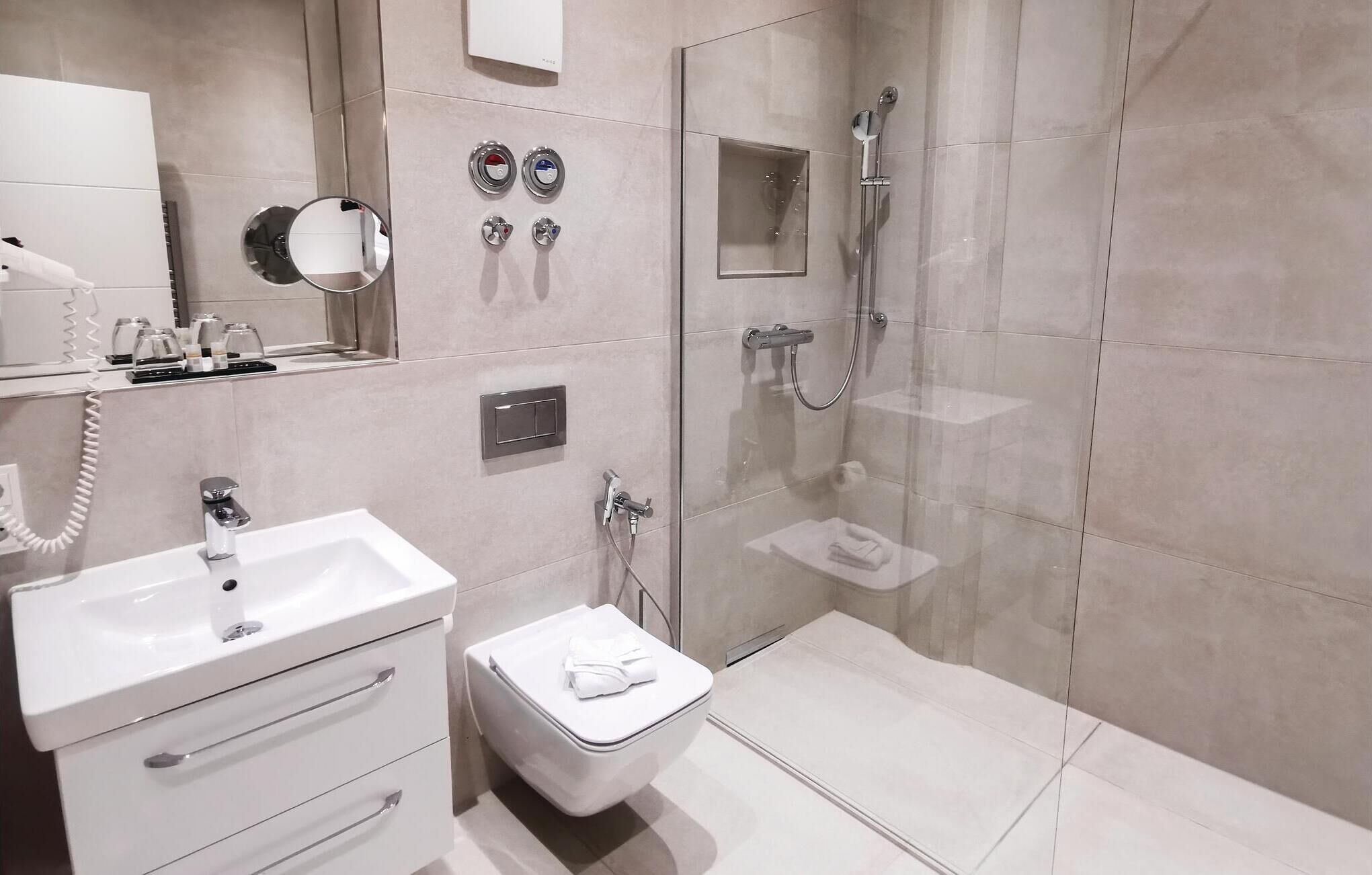 Ein modernes Badezimmer mit Toilette, Waschbecken und Dusche.