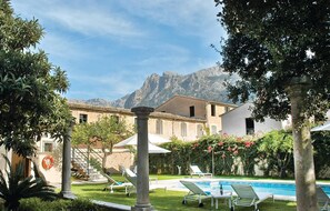 A pool area with lounge chairs and a view of mountains. - 7 bedroom cozy home in Sóller (Sóller)