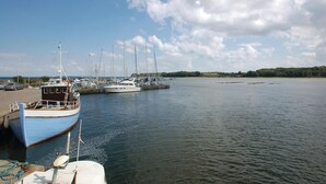 Ein Yachthafen mit mehreren angedockten Booten, ruhigem Wasser und einem klaren Himmel.